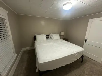 a bedroom with a bed with white sheets and pillows at The Perazim in Akron