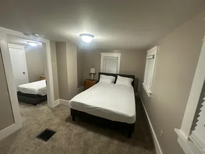 a small bedroom with two beds and a mirror at The Perazim in Akron