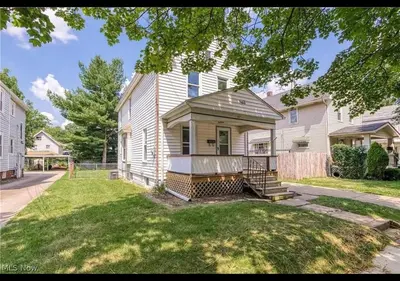 a large white house with a porch and a yard at The Perazim in Akron