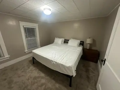 a bedroom with a bed with white sheets and pillows at The Perazim in Akron