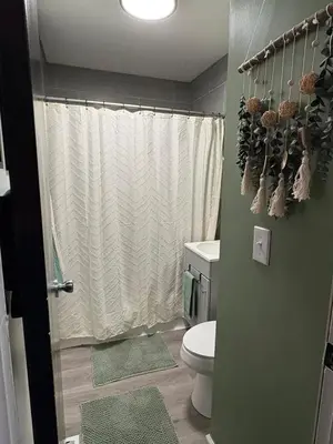a bathroom with a white shower curtain and a toilet at HiddenJewel in Springfield