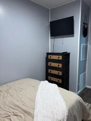 a bedroom with a bed and a dresser and a flat screen tv at HiddenJewel in Springfield