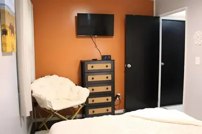 a bedroom with a bed and a dresser and a television at HiddenJewel in Springfield