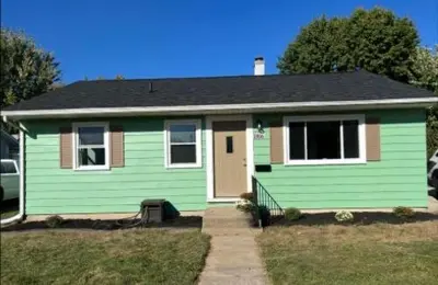 a green house with a black roof at HiddenJewel in Springfield