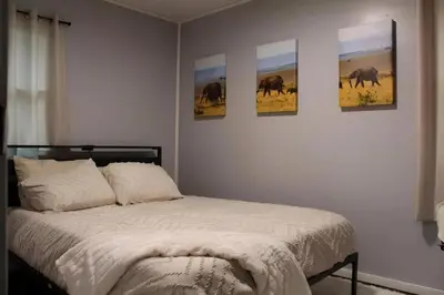 a bedroom with four pictures of elephants on the wall at HiddenJewel in Springfield