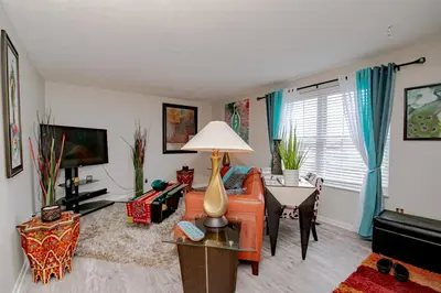 a living room with an orange couch and a table at Lovely Eclectic Duplex - Peaceful Neighborhood in Trotwood