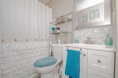 a white bathroom with a toilet and a sink at Lovely Eclectic Duplex - Peaceful Neighborhood in Trotwood