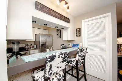a kitchen with a counter and two bar chairs at Lovely Eclectic Duplex - Peaceful Neighborhood in Trotwood