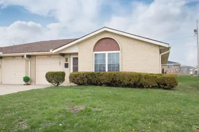 a house with a green lawn in front of it at Lovely Eclectic Duplex - Peaceful Neighborhood in Trotwood