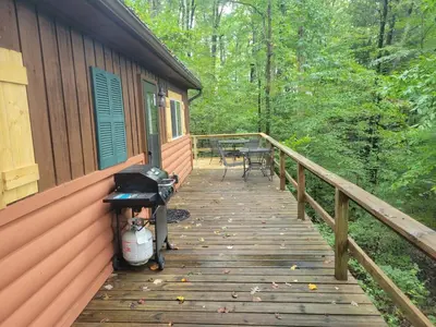a wooden porch of a cabin with a table and chairs at Mountainside Cabin, Secluded, Hot Tub, Lake Accessible in Rockbridge