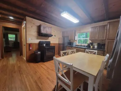 a kitchen with a table and a dining room at Mountainside Cabin, Secluded, Hot Tub, Lake Accessible in Rockbridge