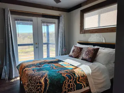 a bedroom with a bed and a large window at Nature Mystique Retreat 3 Bedroom Moroccan Cabin in Creola