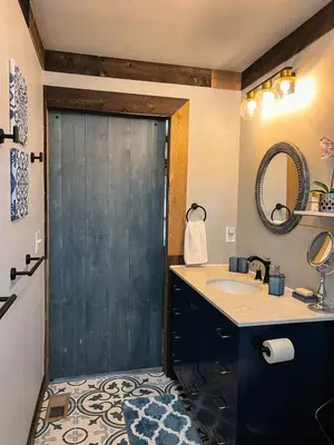 a bathroom with a sink and a gray door at Nature Mystique Retreat 3 Bedroom Moroccan Cabin in Creola