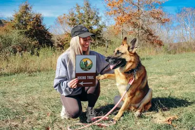a woman holding a sign next to a dog at Nature Mystique Retreat 3 Bedroom Moroccan Cabin in Creola