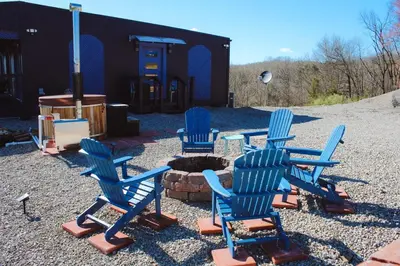 a group of blue chairs sitting around a fire pit at Nature Mystique Retreat 3 Bedroom Moroccan Cabin in Creola