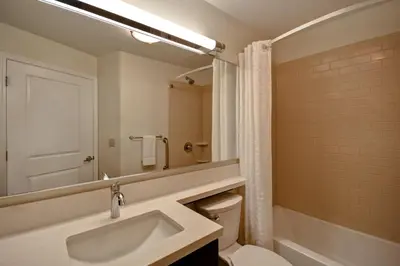 a bathroom with a sink and a toilet and a mirror at Candlewood Suites St Clairsville Wheeling Area by IHG in Saint Clairsville