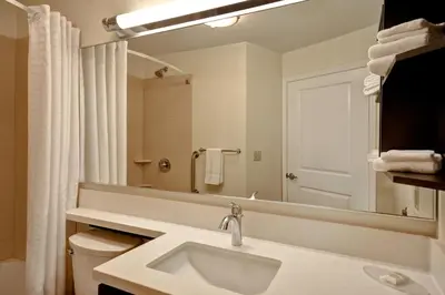 a white bathroom with a sink and a mirror at Candlewood Suites St Clairsville Wheeling Area by IHG in Saint Clairsville