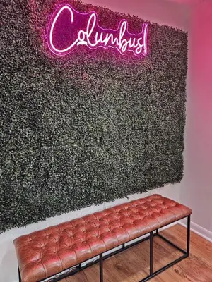 a red bench in front of a wall with a neon sign at Clintonville Charmer - Central, Arcade, Selfie Wall in Columbus