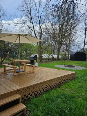 a wooden deck with a picnic table and an umbrella at Clintonville Charmer - Central, Arcade, Selfie Wall in Columbus