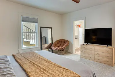 a bedroom with a flat screen tv and a chair at 3 Mi to Downtown Youngstown Updated Apartment in Youngstown
