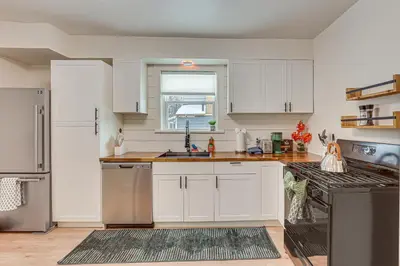 a kitchen with white cabinets and stainless steel appliances at 3 Mi to Downtown Youngstown Updated Apartment in Youngstown