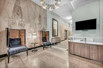 a living room with two chairs and a flat screen tv at Your Downtown Oasis, Pool Gym in Building Steps from Dining and Top Sights in Cleveland