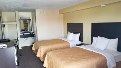 a hotel room with two beds and a television at Greenfield Inn in Greenfield