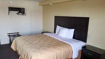 a bedroom with a large bed with a brown headboard at Greenfield Inn in Greenfield