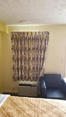 a bedroom with a bed and a window with a couch at Greenfield Inn in Greenfield