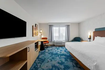 a hotel room with a bed and a flat screen tv at Hampton Inn Mt. Vernon Oh in Academia