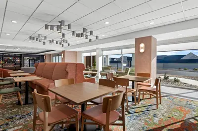 a restaurant with tables and chairs and a couch at Hampton Inn Mt. Vernon Oh in Academia