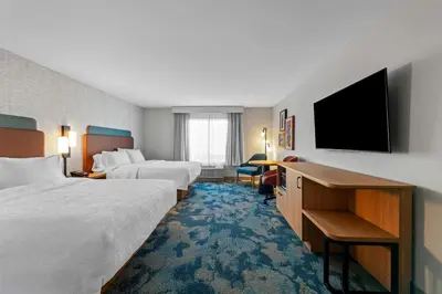 a hotel room with two beds and a flat screen tv at Hampton Inn Mt. Vernon Oh in Academia