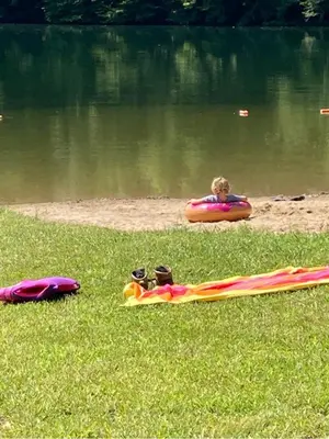 a child is in an inflatable raft on a body of water at Lake Life, Hocking Hills, Hot Tub, Fireplace, Pond in Rockbridge