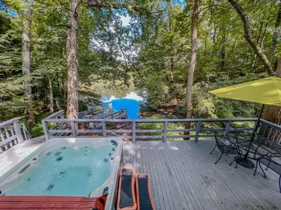 a hot tub on a deck with a table and chairs at Lake Life, Hocking Hills, Hot Tub, Fireplace, Pond in Rockbridge