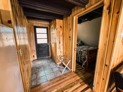 an empty hallway in a log cabin with a door at Whispering Waters, Hocking Hills, Hot Tub, Pond in Rockbridge