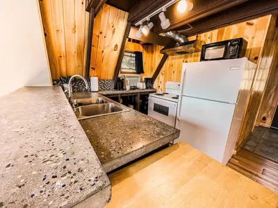 a kitchen with a white refrigerator and a sink at Whispering Waters, Hocking Hills, Hot Tub, Pond in Rockbridge