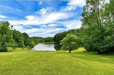 a view of a river with trees and a green field at Edgewater Escape, Hocking Hills, Hot Tub, Pond in Rockbridge