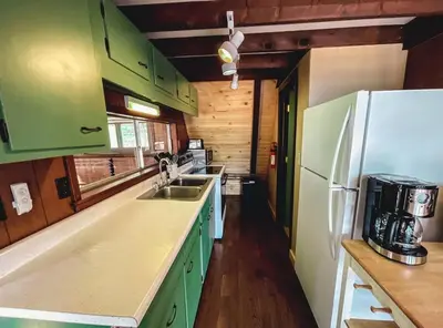 a kitchen with green cabinets and a white refrigerator at Edgewater Escape, Hocking Hills, Hot Tub, Pond in Rockbridge
