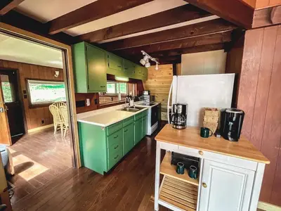 a kitchen with green cabinets and a white refrigerator at Edgewater Escape, Hocking Hills, Hot Tub, Pond in Rockbridge