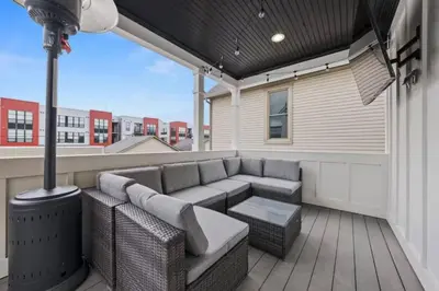 a patio with a couch and a table on a deck at Jungle House Luxury Homes - Columbus Downtown Short North - Near Convention Center & Nationwide Arena - Sleeps up to 15 - Free Parking - Over 5,800 Five Stars in Columbus