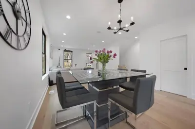 a dining room with a table and chairs and a clock at Jungle House Luxury Homes - Columbus Downtown Short North - Near Convention Center & Nationwide Arena - Sleeps up to 15 - Free Parking - Over 5,800 Five Stars in Columbus