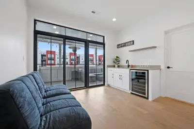 a living room with a blue couch and a kitchen at Jungle House Luxury Homes - Columbus Downtown Short North - Near Convention Center & Nationwide Arena - Sleeps up to 15 - Free Parking - Over 5,800 Five Stars in Columbus