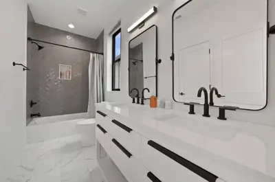 a white bathroom with two sinks and a shower at Jungle House Luxury Homes - Columbus Downtown Short North - Near Convention Center & Nationwide Arena - Sleeps up to 15 - Free Parking - Over 5,800 Five Stars in Columbus