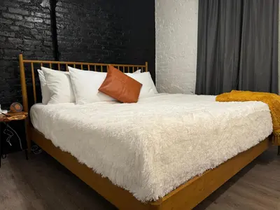 a bedroom with a bed with white sheets and pillows at Jungle House Luxury Stays - Columbus Downtown Short North in Columbus