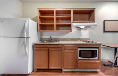 a kitchen with wooden cabinets and a white refrigerator at Extended Stay America Select Suites - Dayton - Miamisburg in Dayton