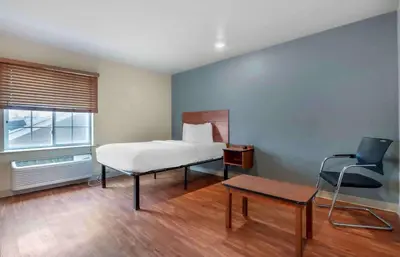 a bedroom with a bed and a chair and a table at Extended Stay America Select Suites - Dayton - Miamisburg in Dayton