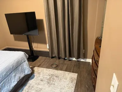 a bedroom with a bed and a television on a stand at The Gather Grove in Toledo