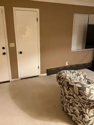 an empty room with a bed and a door at The Gather Grove in Toledo