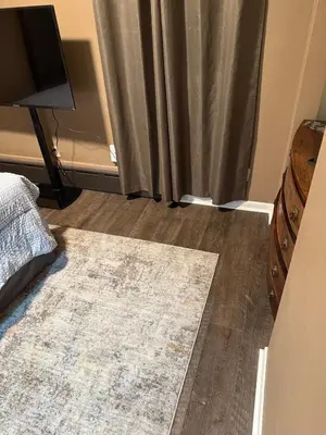 a bedroom with a rug on the floor and a curtain at The Gather Grove in Toledo
