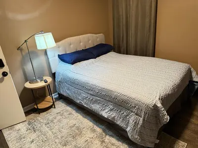 a bedroom with a bed with a blue pillow and a lamp at The Gather Grove in Toledo